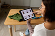 © Valentina Barreto/Stocksy - Woman looking at clothes on tablet