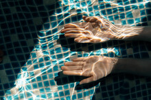 Anonymous woman with hands under water
