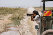 © Kike Arnaiz/Stocksy - Curly woman with camera in safari car