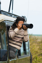 Female Photographer With Camera In Safari Car