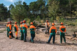 © Ezequiel Giménez/Stocksy - Group of woodcutters listening instruction