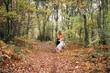 © Daniel Gonzalez/Stocksy - A beautiful woman has fun with her dog in autumn
