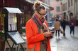 © Anna Berkut/Stocksy - stylish mature woman using smartphone in the city