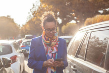 Mature Business Woman Using Smartphone Near Her  Car