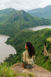 © Kike Arnaiz/Stocksy - Female sitting on top of mountains
