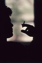 Man 's Silhouette At The Window Smoking A Cigarette 