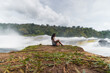 © Kike Arnaiz/Stocksy - Happy Arab woman enjoying waterfall