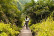 © Kike Arnaiz/Stocksy - Tourist woman on pathway among lush plants