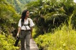 © Kike Arnaiz/Stocksy - Tourist woman on pathway among lush plants