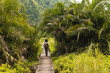 © Kike Arnaiz/Stocksy - Tourist woman on pathway walking on jungle