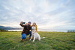 © Daniel Gonzalez/Stocksy - Cheerful couple taking selfie with dog