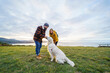 © Daniel Gonzalez/Stocksy - Couple with dog on meadow