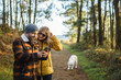 © Daniel Gonzalez/Stocksy - Couple using smartphone in park