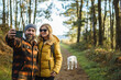 © Daniel Gonzalez/Stocksy - Couple taking selfie in autumn park