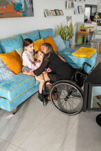 Mother In Wheelchair Playing With Her Daughter