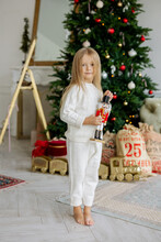 A Girl With A Nutcracker Toy Near Christmas Tree