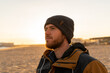 © Alba Vitta/Stocksy - Portrait of man enjoying sunset  winter beach