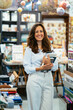 © Manu Padilla/Stocksy - Cheerful teacher with books in library