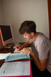 © Erin Brant/Stocksy - Teen boy with cochlear implant studying