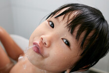 Cute Asian little girl playing in the bath

