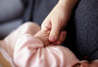 © ChaoShu Li/Stocksy - Closeup of newborn Asian baby's hand and mother's hand