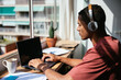 © BONNINSTUDIO/Stocksy - Hispanic student using laptop at home