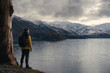 © Pajaros Volando - Man standing by a tree in Lake Hawea during winter.