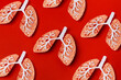 © Julia Potato/Stocksy - Paper craft lungs with virus on red background