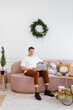 © Alina Hvostikova/Stocksy - Young man using laptop on sofa