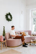 © Alina Hvostikova/Stocksy - Young man using laptop on sofa