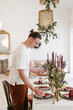 © Alina Hvostikova/Stocksy - Man serving table for Christmas dinner
