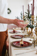 © Alina Hvostikova/Stocksy - Man serving table for Christmas dinner