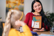 © Studio Marmellata/Stocksy - Asian nanny teaching girl English