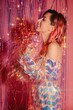 © Liliya Rodnikova/Stocksy - Happy woman playing with tinsel