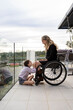 © Santi Nuñez/Stocksy - Mother in wheelchair enjoying with her daughter