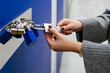 © VICTOR TORRES/Stocksy - Anonymous woman opening padlocks on a blue door of a storage roo