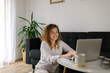© STUDIO TAURUS/Stocksy - Happy woman using laptop at home for video call