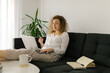 © STUDIO TAURUS/Stocksy - Caucasian woman having video call via laptop indoors