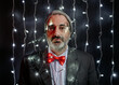 © Jimena Roquero/Stocksy - Man in bow tie with Christmas lights on his head