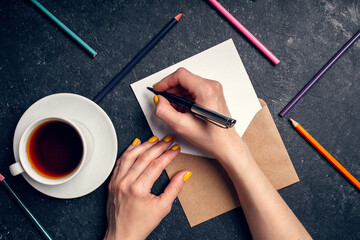 Wall Mural - A woman writes plans for 2022 on black background top view