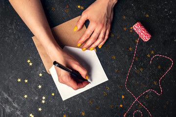Wall Mural - A woman writes plans for 2022 on black background top view