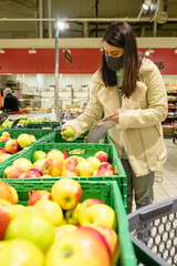 Wall Mural - woman choosing apples put in bag groceries store