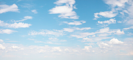 Wall Mural - Blue sky and white clouds background - Pillowy clouds cover a blue sky in the background