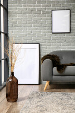 Stylish Interior With Grey Sofa On Brick Wall Background