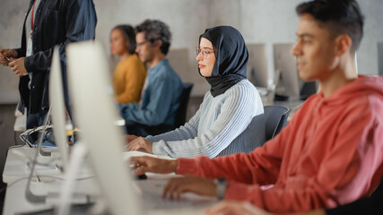 Fototapete - Female Muslim Student in Hijab, Studying in University. She Works on Desktop Computer in College with Diverse Multiethnic Classmates. Applying Her Knowledge to Acquire Academic Skills in Class.