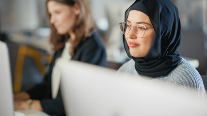 Sticker - Beautiful Portrait of a Female Muslim Student in Hijab, Studying in University. She Works on Desktop Computer in College. Applying Her Knowledge to Acquire Academic Skills in Class.