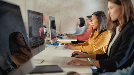 Fototapete - Diverse Multiethnic Group of Female and Male Students Sitting in College Room, Learning Computer Science. Young Scholars Study Information Technology on Computers in University, Writing Code in Class.