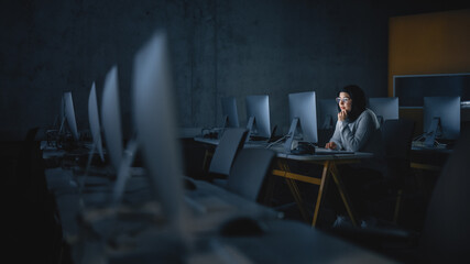 Fototapete - Young Muslim Female Student Sitting Alone in College Informatics Room, Working Late Evenings on Computer Science Project. Scholar Study IT on Computer in University, Writing Homework in Class.
