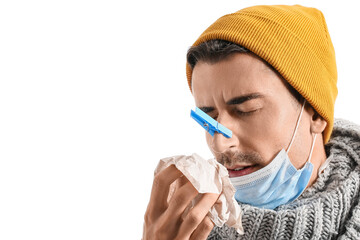 Poster - Ill young man with clothespin on his nose against white background