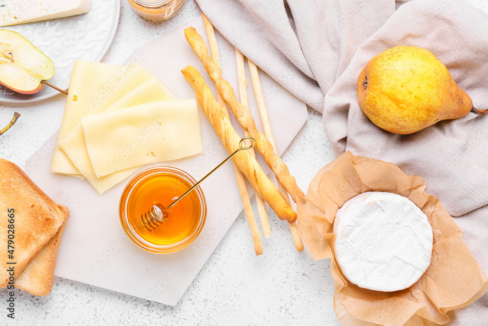 Composition with honey, cheese and crackers on light background
